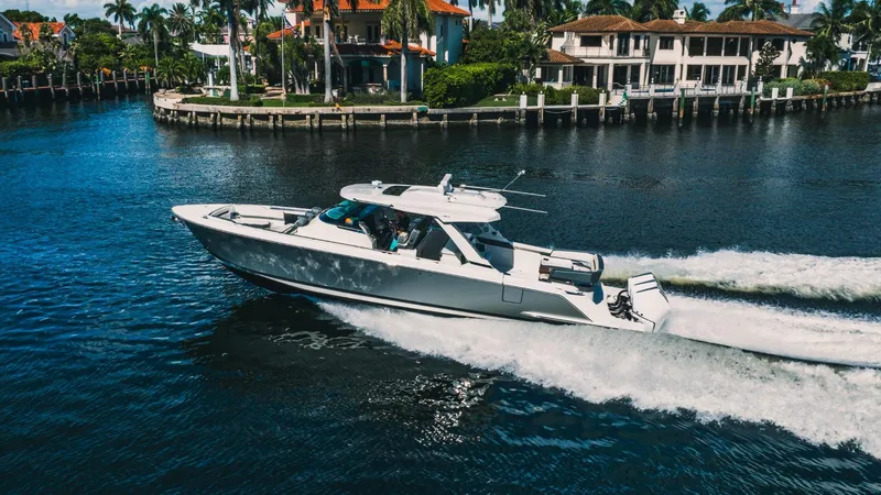 Slide: The Image of 2021 Tiara Sport 43 LS cruising on a sunny day near waterfront homes. - 5