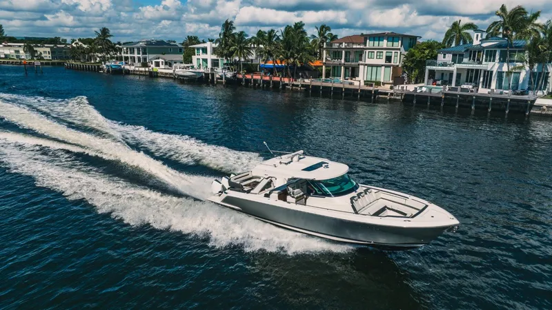 Slide: The Image of 2021 Tiara Sport 43 LS cruising on a scenic waterfront. - 8