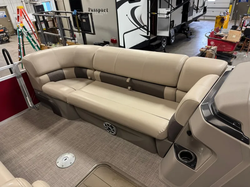 Slide: The Image of 2024 Sun Tracker Party Barge 22 XP3 interior with beige seating in a showroom. - 11