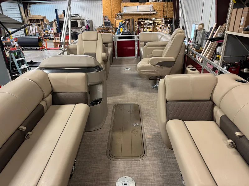 Slide: The Image of 2024 Sun Tracker Party Barge 22 XP3 interior with beige seating in a workshop setting. - 13