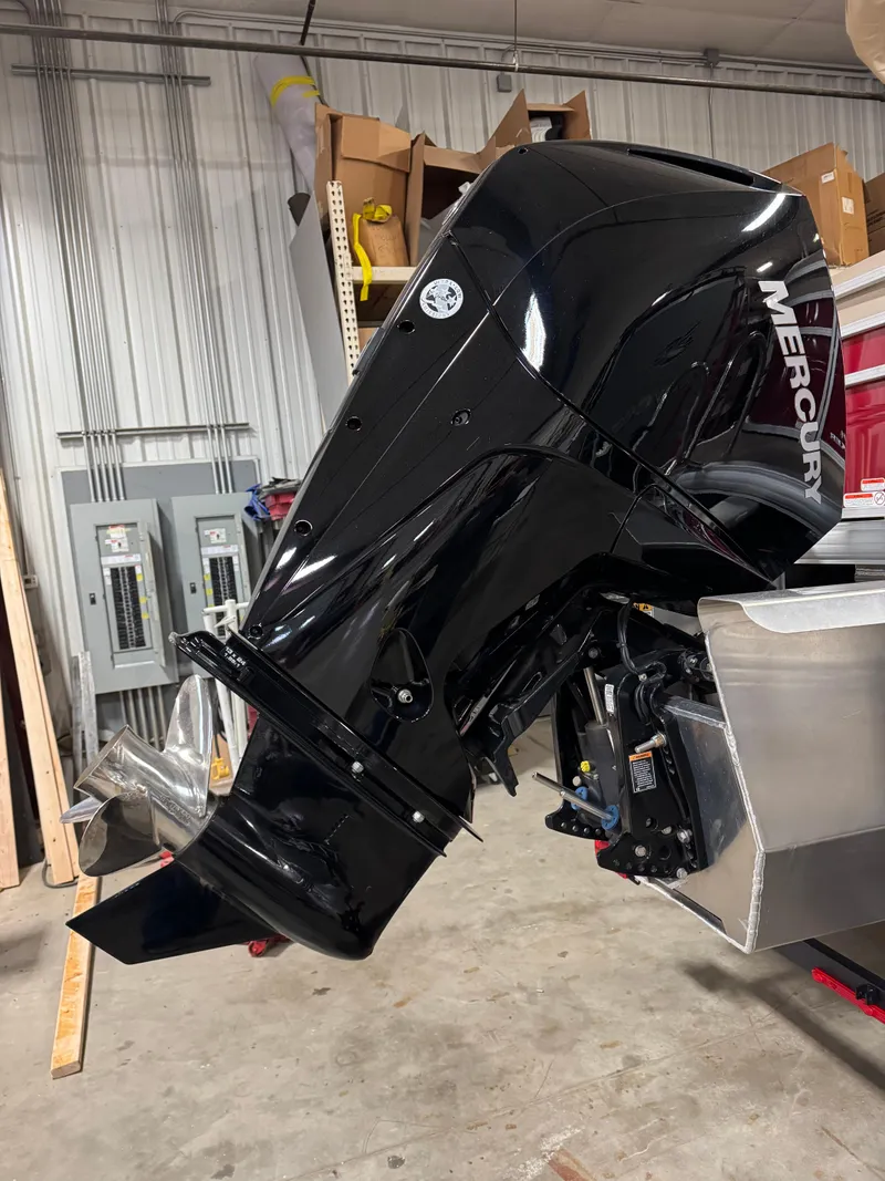 Slide: The Image of 2024 Sun Tracker Party Barge 22 XP3 with Mercury outboard motor in a garage. - 3