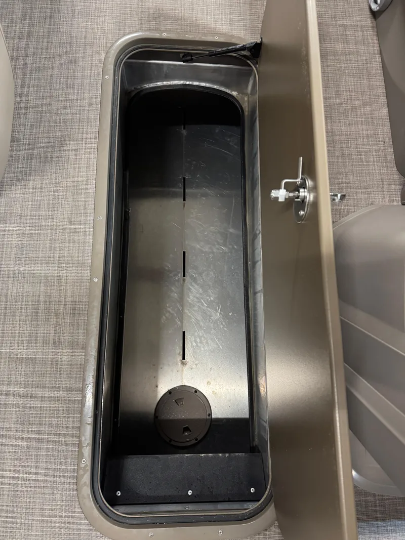 Slide: The Image of 2024 Sun Tracker Party Barge 22 XP3 storage compartment with secure latch on textured flooring. - 4