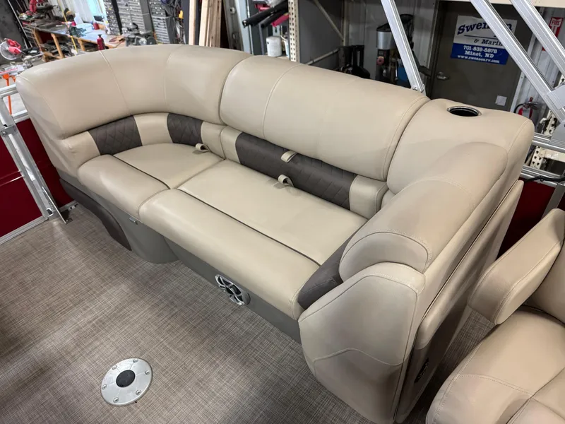 Slide: The Image of 2024 Sun Tracker Party Barge 22 XP3 beige seating with cup holder, in showroom setting. - 7