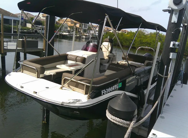 Slide: The Image of 2022 Bayliner Element XR7 boat docked at a marina with a black canopy. - 2