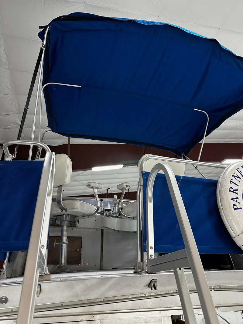 Slide: The Image of 1975 Marinette 32' Cruiser with blue canopy and ladder in indoor storage. - 13