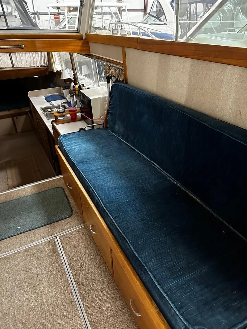 Slide: The Image of 1975 Marinette 32' Cruiser interior with blue cushioned seating and wooden accents. - 22