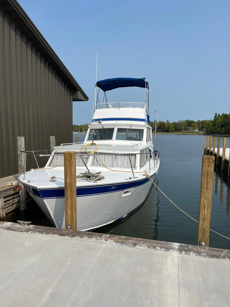 Slide: The Image of 1975 Marinette 32' Cruiser docked by a wooden pier on a sunny day. - 3