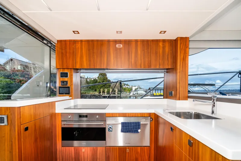 Slide: The Image of Modern kitchen on 2017 Sunseeker Manhattan 52 yacht with wood cabinetry and stainless steel appliances. - 13