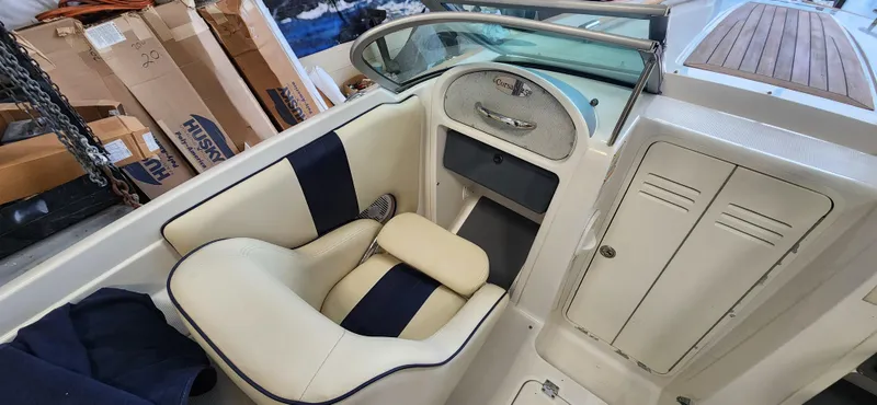 Slide: The Image of 2004 Chris-Craft Corsair 25 boat interior with beige and navy seating. - 10