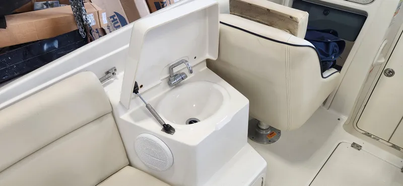 Slide: The Image of 2004 Chris-Craft Corsair 25 boat interior with sink and seating. - 13