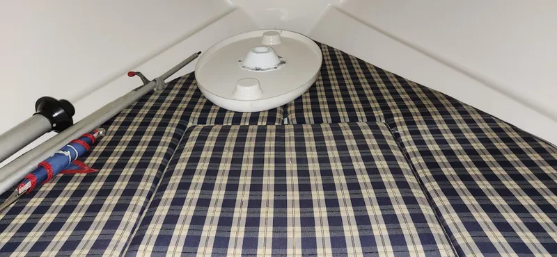 Slide: The Image of 2004 Chris-Craft Corsair 25 interior with plaid upholstery and boat accessories. - 18