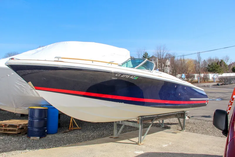 Slide: The Image of 2004 Chris-Craft Corsair 25 boat on a stand, black hull with red stripe. - 2