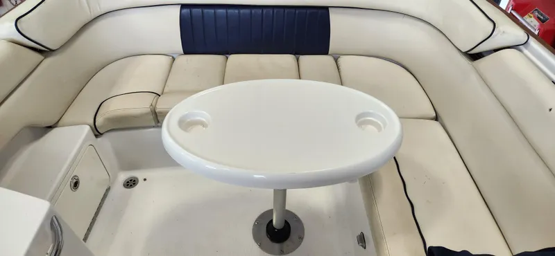 Slide: The Image of 2004 Chris-Craft Corsair 25 boat interior with white seating and oval table. - 20