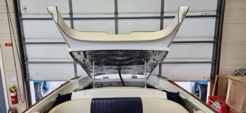 Slide: The Image of 2004 Chris-Craft Corsair 25 boat with open engine hatch in a garage. - 24