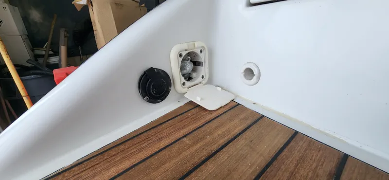 Slide: The Image of 2004 Chris-Craft Corsair 25 boat interior with wooden flooring and utility ports. - 26