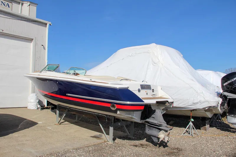 Slide: The Image of 2004 Chris-Craft Corsair 25 boat on dry dock, blue hull with red stripe. - 3