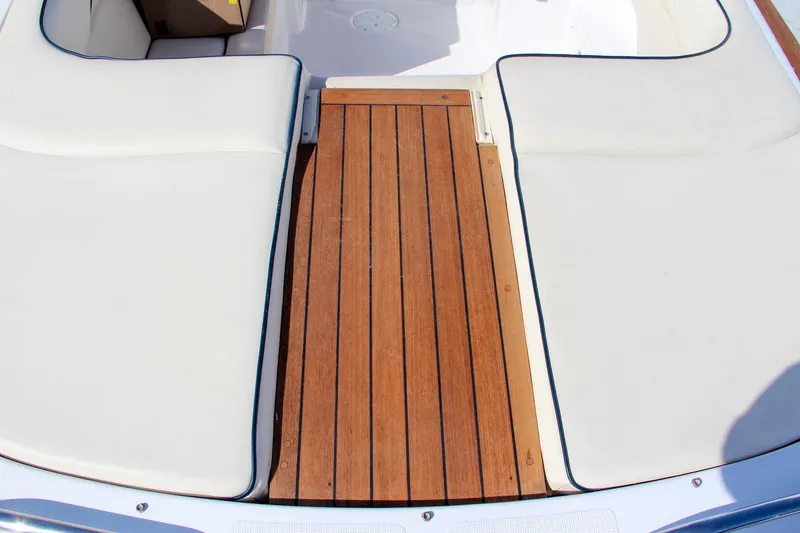 Slide: The Image of 2004 Chris-Craft Corsair 25 boat with teak deck and white cushioned seating. - 32
