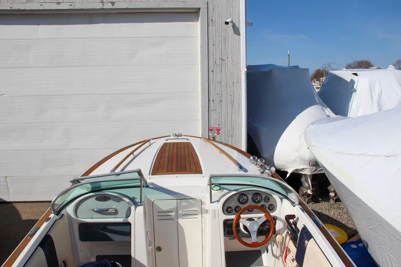 Slide: The Image of 2004 Chris-Craft Corsair 25 boat docked near a storage facility. - 33