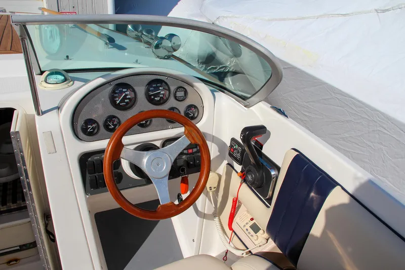 Slide: The Image of 2004 Chris-Craft Corsair 25 boat cockpit with wooden steering wheel and instrument panel. - 36