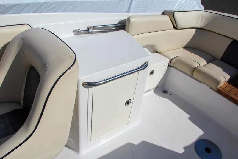 Slide: The Image of 2004 Chris-Craft Corsair 25 boat interior with beige seating and storage compartment. - 42