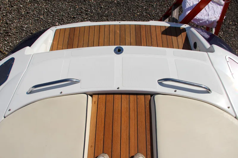 Slide: The Image of 2004 Chris-Craft Corsair 25 boat deck with teak flooring and cushioned seating. - 43