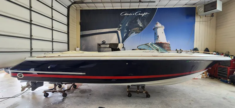 Slide: The Image of 2004 Chris-Craft Corsair 25 boat in a garage with a nautical backdrop. - 5