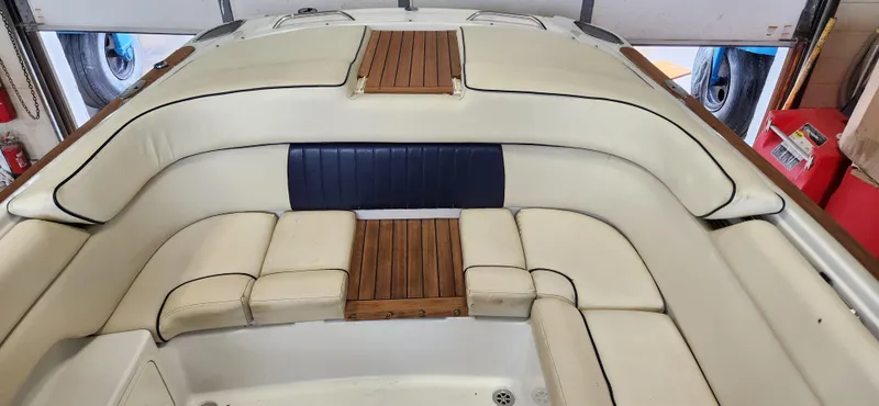 Slide: The Image of 2004 Chris-Craft Corsair 25 boat interior with cream leather seating and wooden accents. - 8