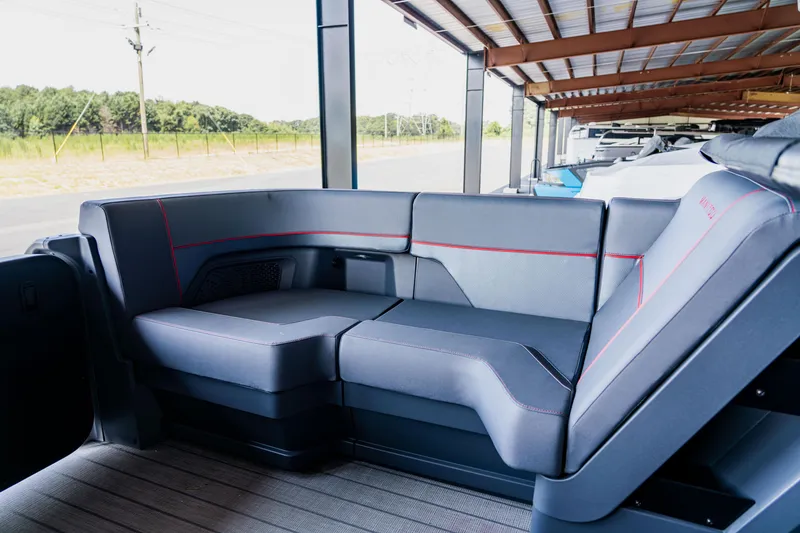Slide: The Image of 2023 Manitou 22 Explore Bench interior seating under a covered dock. - 7