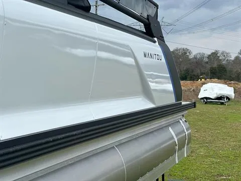 Slide: The Image of 2024 Manitou 24 Explore pontoon boat side view on grass. - 4
