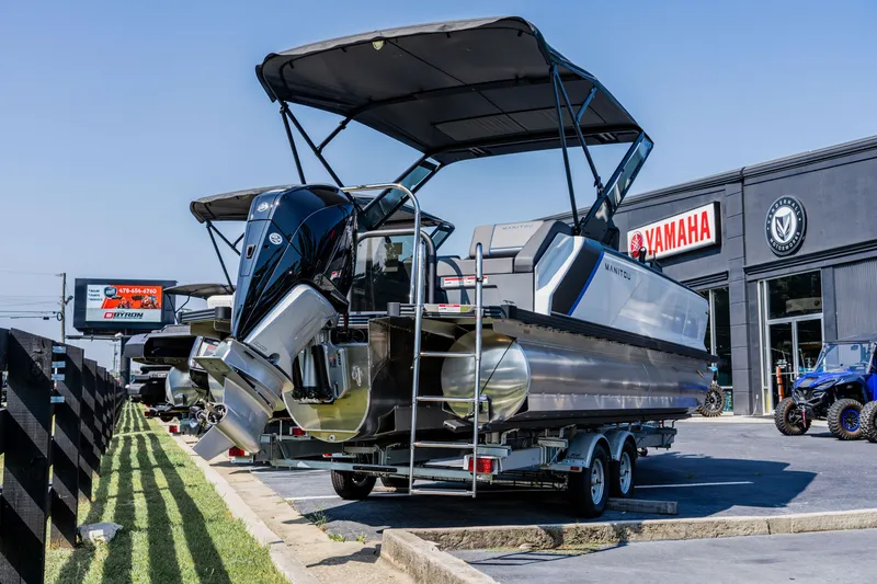 The Image of 2023 Manitou 24 EXPLORE SWITCHBACK pontoon boat displayed at a Yamaha dealership. - 1