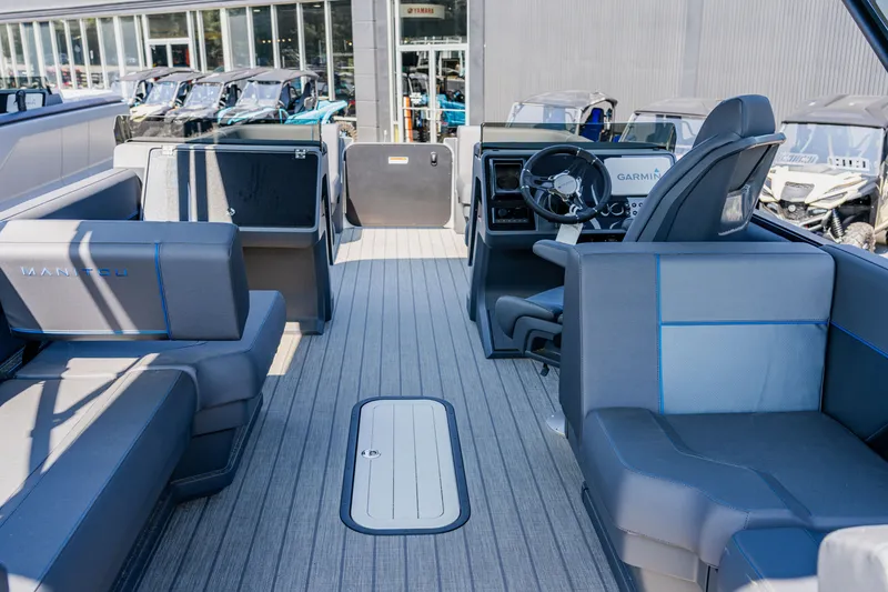 Slide: The Image of 2023 Manitou 24 EXPLORE SWITCHBACK boat interior with seating and steering console. - 2