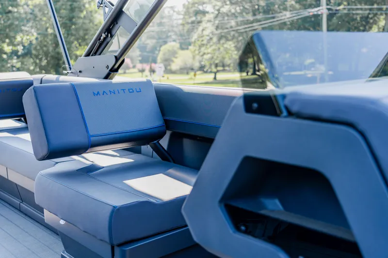 Slide: The Image of 2023 Manitou 24 EXPLORE SWITCHBACK boat interior with blue seating. - 5
