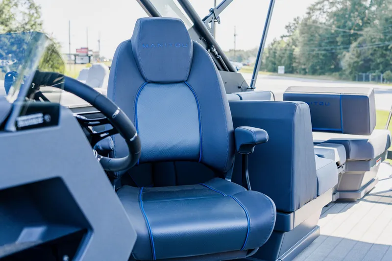 Slide: The Image of 2023 Manitou 24 EXPLORE SWITCHBACK boat interior with blue and gray seating. - 8