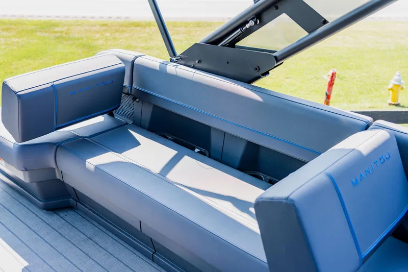 Slide: The Image of 2023 Manitou 24 EXPLORE SWITCHBACK boat interior with blue seating. - 9