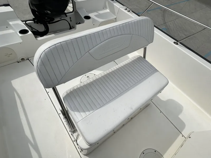 Slide: The Image of 2018 Boston Whaler 190 Montauk boat interior with white cushioned seating. - 10