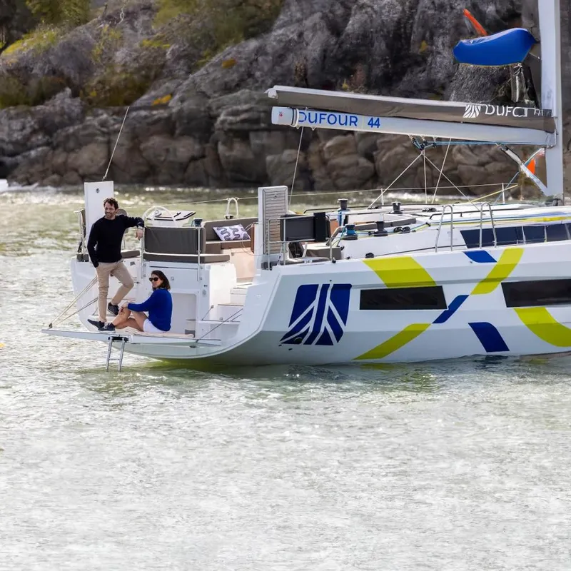 The Image of Dufour 44 sailboat with people relaxing on the deck in calm waters. - 0
