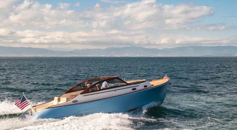 Slide: The Image of 2023 Vento V40 Retro Classic Open boat cruising on the ocean with mountains in the background. - 8