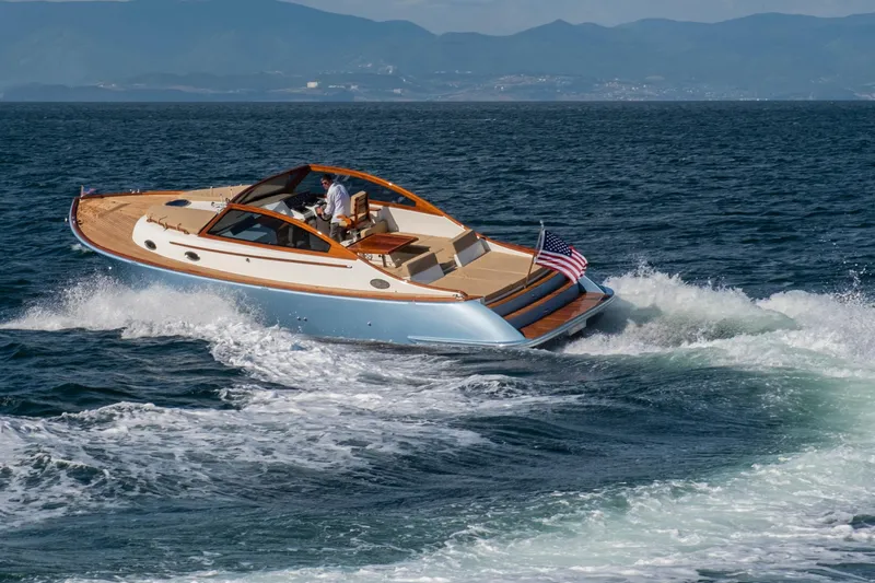 Slide: The Image of Vento V40 Retro Classic Open 2023 yacht cruising on the ocean with mountains in the background. - 9