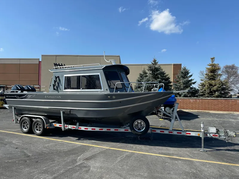 Slide: The Image of 2024 Spartan 260 Maximus Pro XL boat on a trailer in a parking lot. - 0
