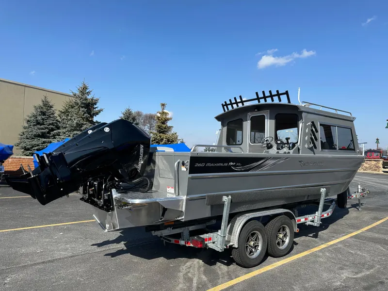 Slide: The Image of 2024 Spartan 260 Maximus Pro XL boat on a trailer in a parking lot. - 1