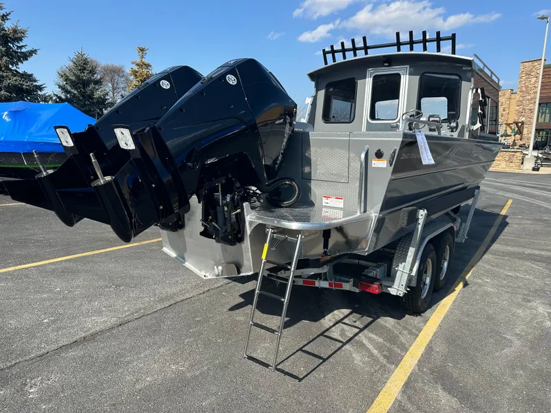 Slide: The Image of 2024 Spartan 260 Maximus Pro XL boat on trailer with dual outboard motors. - 2