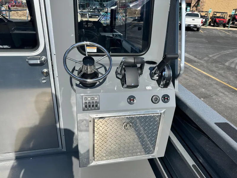 Slide: The Image of 2024 Spartan 260 Maximus Pro XL boat control panel with steering wheel and throttle levers. - 23