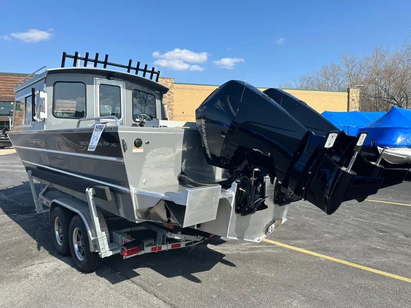 Slide: The Image of 2024 Spartan 260 Maximus Pro XL boat on a trailer with dual outboard motors. - 3