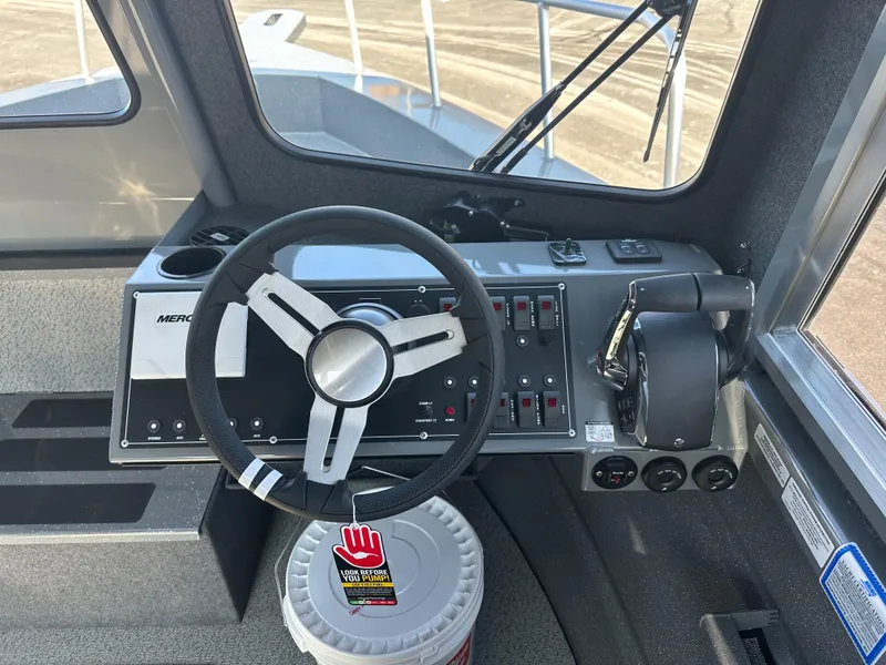 Slide: The Image of 2024 Spartan 260 Maximus Pro XL boat cockpit with steering wheel and control panel. - 7