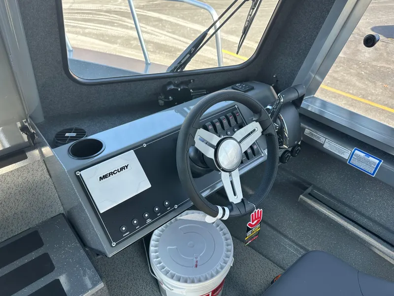 Slide: The Image of 2024 Spartan 260 Maximus Pro XL boat cockpit with steering wheel and Mercury controls. - 8