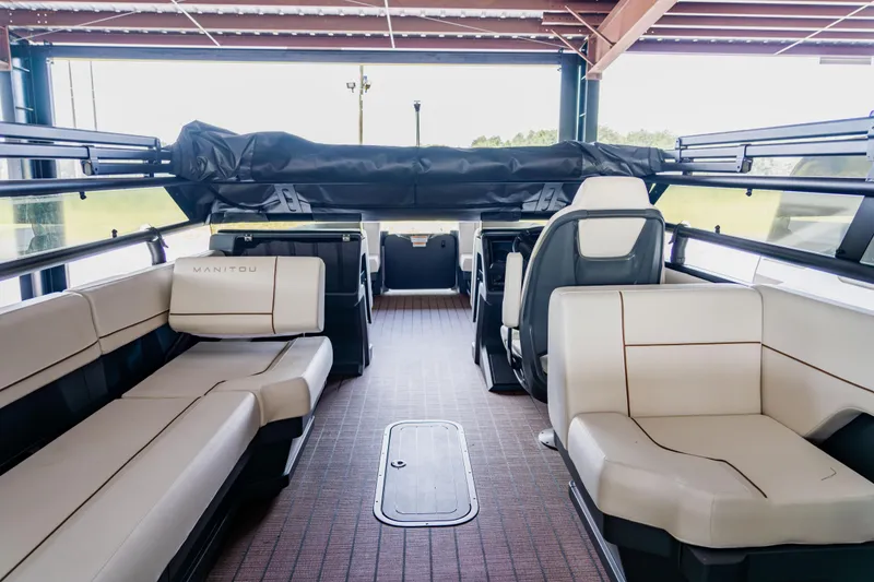 Slide: The Image of Interior of 2024 Manitou 26 Explore SHP575 Switchback pontoon boat with beige seating. - 10
