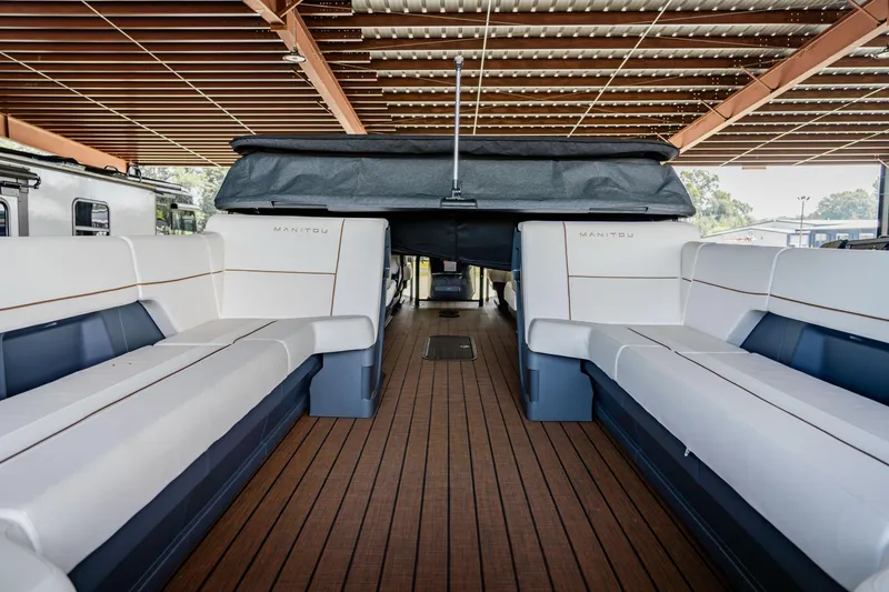 Slide: The Image of 2024 Manitou 26 Explore SHP575 Switchback interior with spacious seating and wooden flooring. - 3