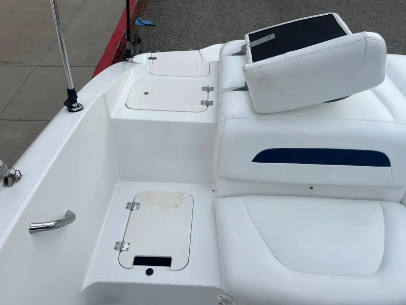 Slide: The Image of 2013 Chaparral 19 Sport H2O boat interior with white seating and storage compartments. - 10
