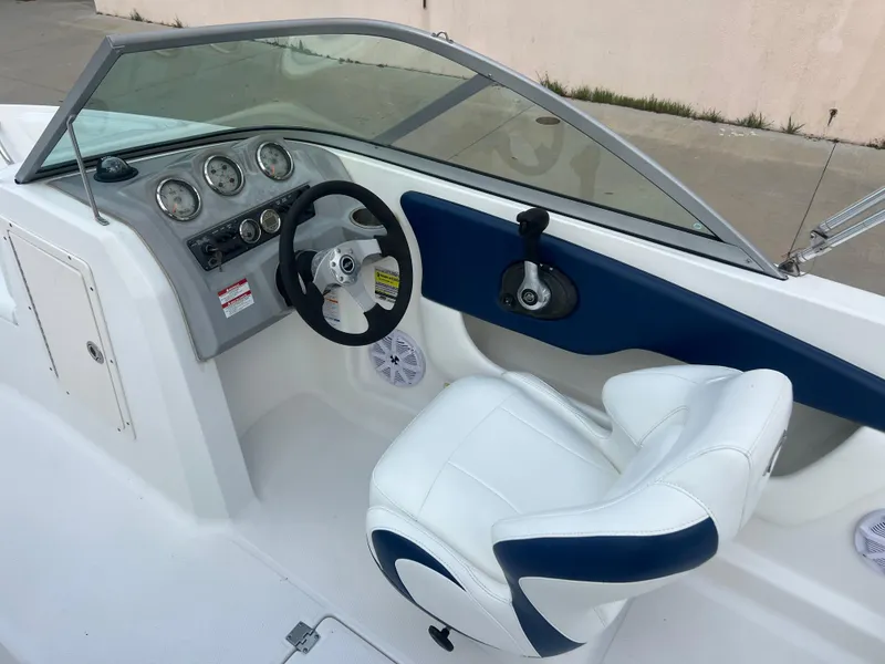 Slide: The Image of 2013 Chaparral 19 Sport H2O boat cockpit with steering wheel and captain's chair. - 12