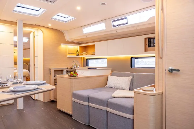 Slide: The Image of Modern interior of 2024 Dufour 44 yacht with cozy seating and dining area. - 17